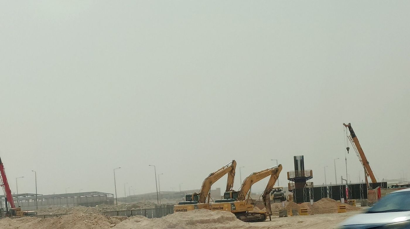 Construction cranes on the outskirts of Riyadh, where outdoor work is prohibited during midday hours when temperatures exceed set thresholds.