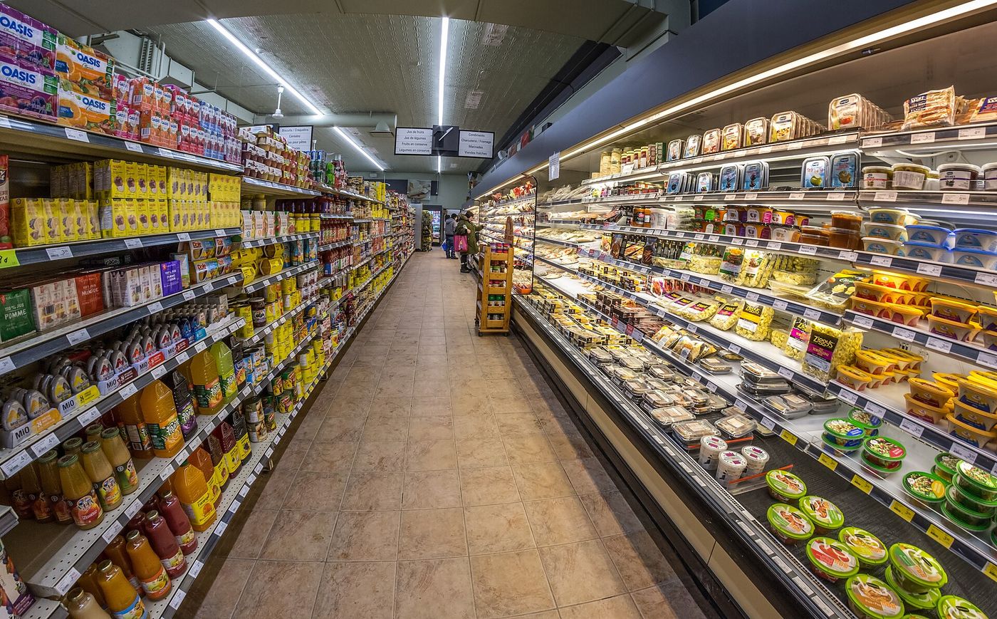 A shopper in a supermarket aisle. German grocers have cut prices on hundreds of staple items since August.